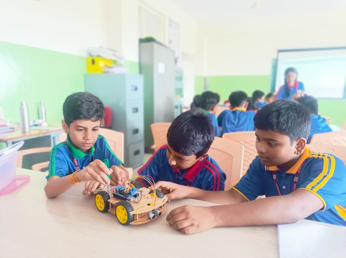 Students working on a robotic claw arm